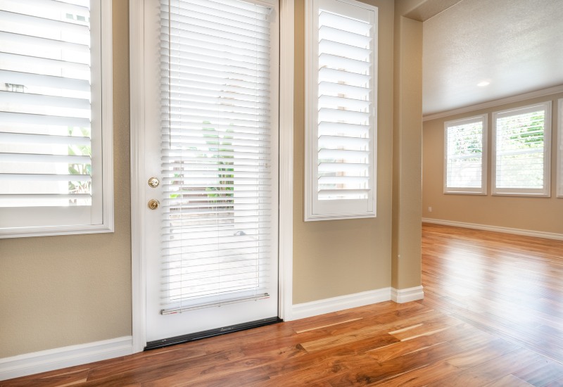 White blinds on glass door and windows in bright living room, Tucson, AZ